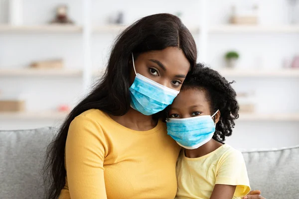 건강 관리. 흑인 어머니와 딸 이 의료용 마스크를 착용하고 집에 있는 모습 — 스톡 사진