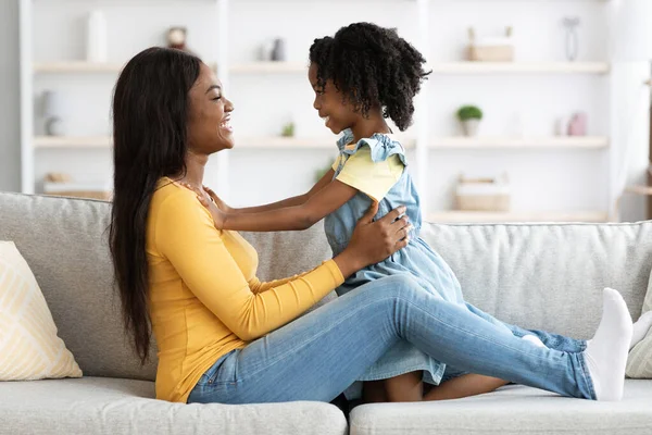 Молода афроамериканська мати та її маленька донечка веселяться вдома — стокове фото