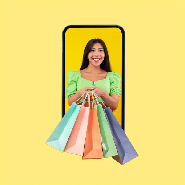 Spännande kvinna tittar ut mobiltelefon skärm med shoppingväskor — Stockfoto