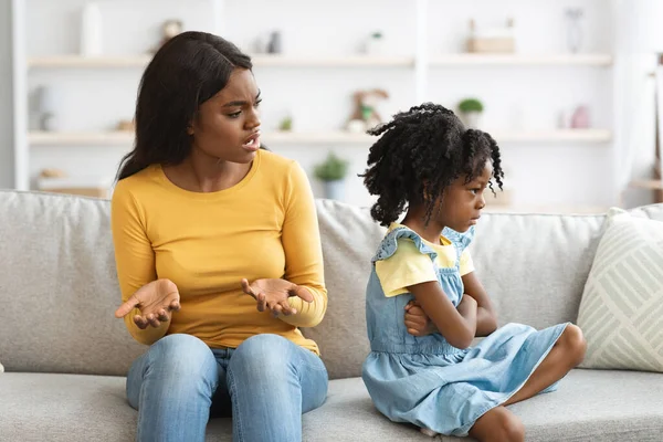 Conflitos entre pais e filhos. Jovem mãe negra repreender ofendido menina — Fotografia de Stock