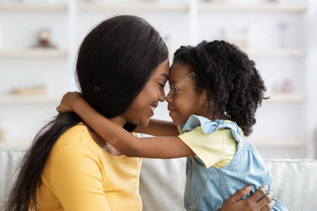 Loving Family. Cute Little Black Girl And Her Mother Embracing At Home