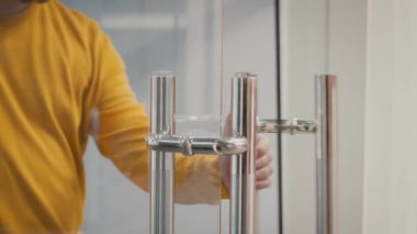 Tanımlanamayan adam ofis odasına giriyor cam kapıyı itiyor ve açıyor.