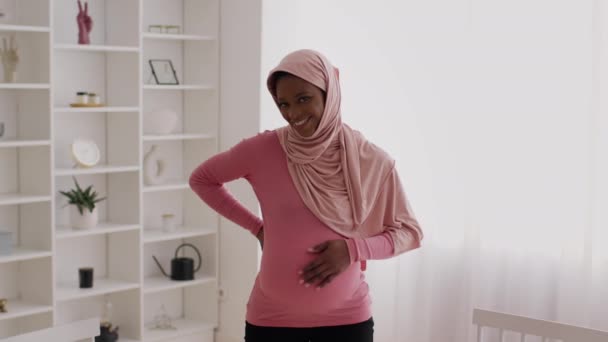 Felice incinta afro-americano signora indossare hijab accarezzando pancia all'interno — Video Stock