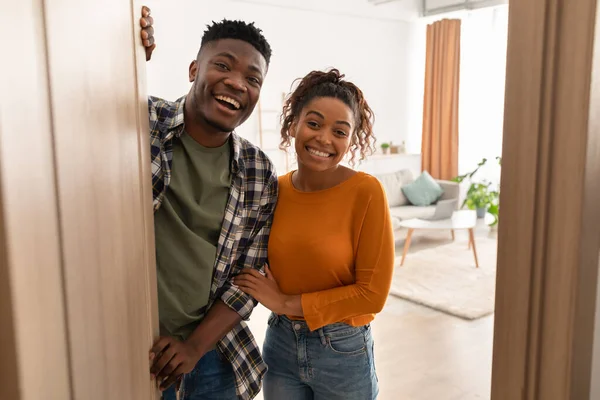 Šťastný africký pár otevření dveří s úsměvem na kameru doma — Stock fotografie