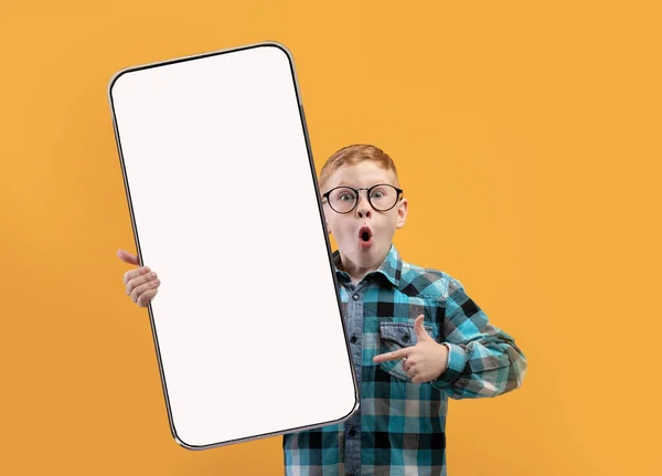 Pequeño niño de la escuela mostrando blanco pantalla del teléfono inteligente vacío — Foto de Stock