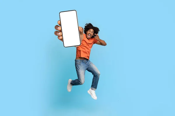 Aufgeregter Afroamerikaner zeigt auf Smartphone-Attrappe — Stockfoto