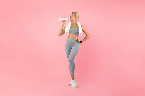 Mujer deportiva bebiendo agua de la botella después de hacer ejercicio —  Fotos de Stock
