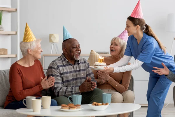 Starší černošky muž má narozeninový večírek v pečovatelském domě — Stock fotografie
