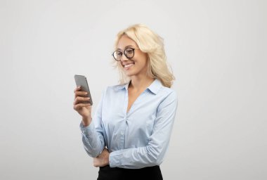 Cep telefonlu genç bayan girişimci portresi ya da hafif stüdyo arka planı üzerinden müşteriyle sohbet etmek