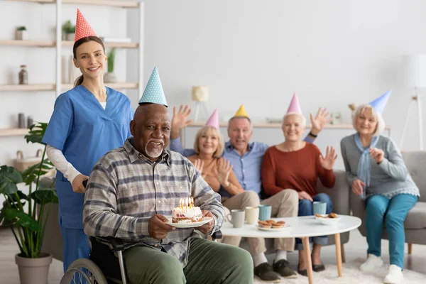 Инвалид старший черный мужчина празднует день рождения в доме престарелых — стоковое фото