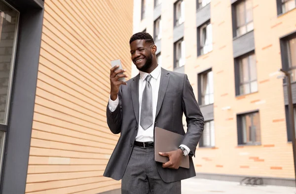 Leende afrikansk amerikansk affärsman chatta med kunden på smartphone, med paus och promenader utomhus — Stockfoto