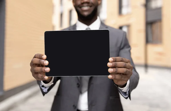 Afrikai-amerikai üzletember bemutató tabletta üres képernyőn, bemutatva helyet a hirdetés, mockup — Stock Fotó