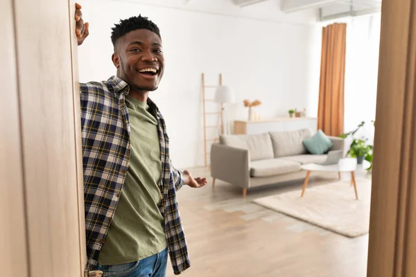 Ευτυχισμένος Αφροαμερικανός ανοίγοντας την πόρτα χαμογελώντας στέκεται στο σπίτι — Φωτογραφία Αρχείου