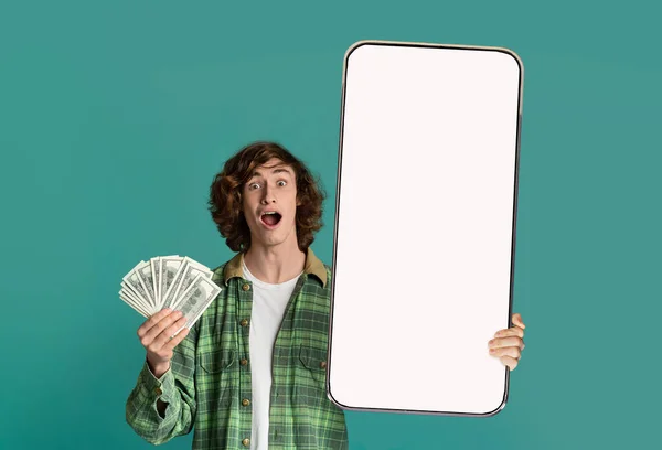 Mężczyzna trzyma pieniądze i duży biały pusty ekran smartfona — Zdjęcie stockowe