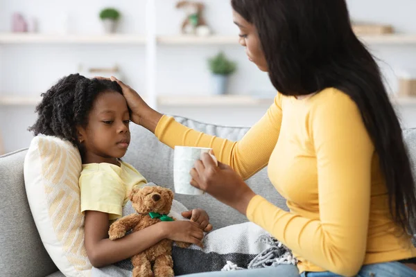 Caring Schwarz Mutter Giving Heiß Tea Bis Sie Ill Kleine Tochter — Stockfoto