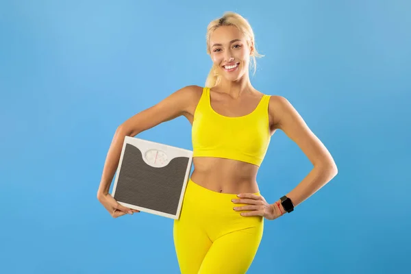 Portret van een sportieve vrouw met weegschalen. Slimming Concept — Stockfoto