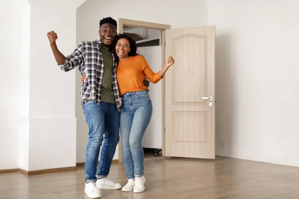 Joyful casal preto Gesturing sim abraçando entre caixas móveis interior — Fotografia de Stock