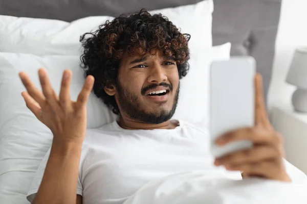 Θυμωμένος ινδιάνος τύπος κοιτάζοντας οθόνη smartphone και gesturing — Φωτογραφία Αρχείου
