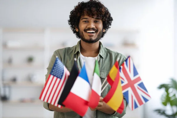 Cheerful indian guy holding bunch of flags — Stock Photo, Image