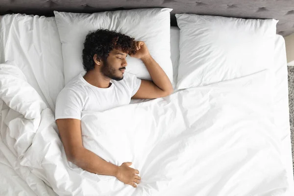 Visão superior do cara hindu dormindo sozinho na cama — Fotografia de Stock