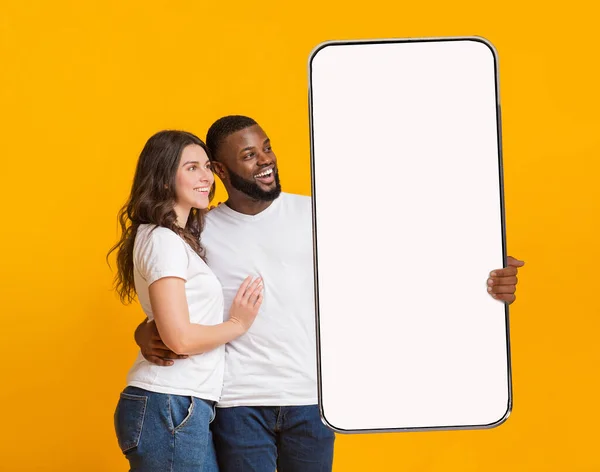 Exotisches Paar zeigt großen weißen leeren Smartphone-Bildschirm — Stockfoto