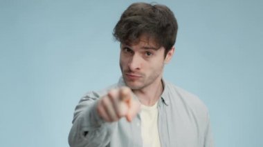 Öfke ve öfke kavramı. Genç öfkeli adamın yakın portresi kameraya parmak atıyor ve yumrukla azarlıyor.