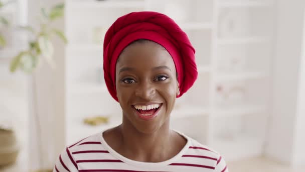 Porträt einer glücklichen Afroamerikanerin, die zu Hause Kopftuch trägt — Stockvideo