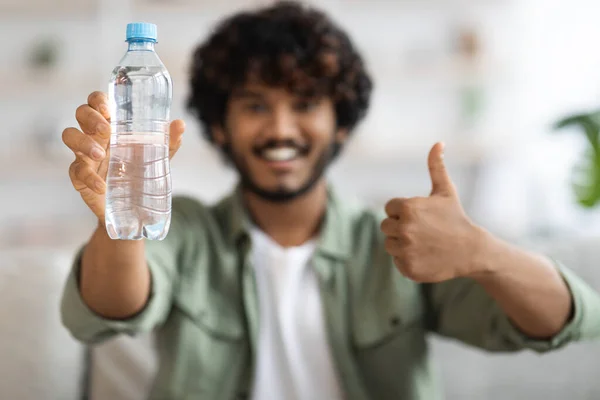 Felice uomo indiano che mostra bottiglia d'acqua e pollice in su — Foto Stock