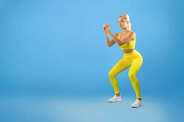 Determinada jovem mulher fazendo exercício de agachamento profundo — Fotografia de Stock