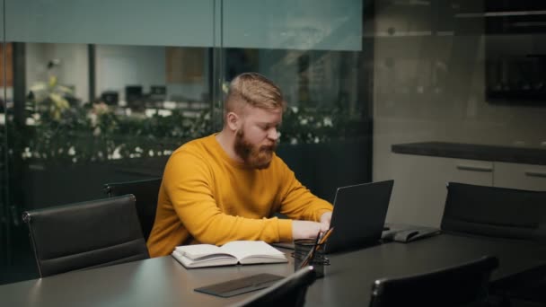Uomo imprenditore millenario che utilizza il computer portatile che lavora seduto online sul posto di lavoro — Video Stock