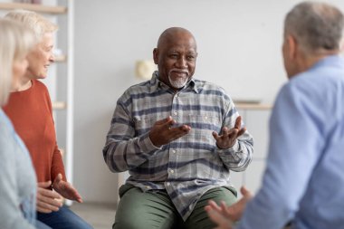 Neşeli Afrikalı Amerikalı yaşlı adam koçla konuşuyor.