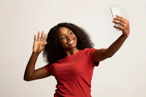 Gelukkig jong zwart vrouw met smartphone het maken van video bellen of het nemen van selfie — Stockfoto