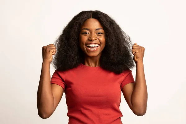 Большая победа. Портрет восхищенной чернокожей женщины, поднимающей руки с возбуждением — стоковое фото
