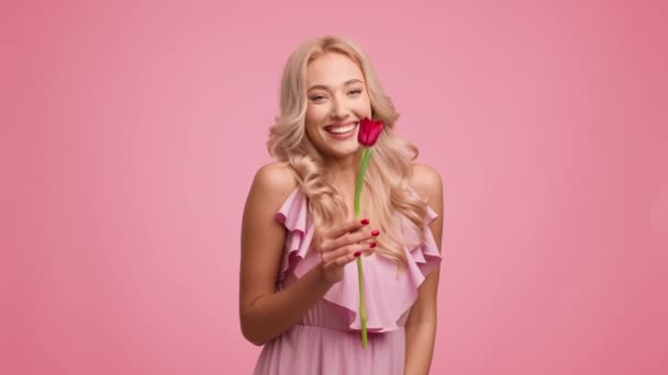 ピンクを背景にチューリップの花を祝うブロンドの女性 — ストック動画