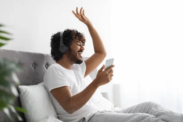 Fröhlicher Hindu mit drahtlosem Headset und Smartphone-Gesang — Stockfoto