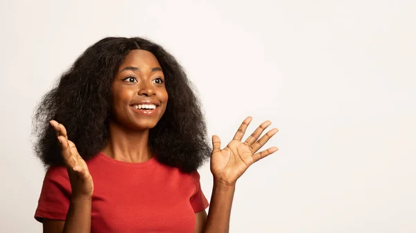 Отличное предложение. Молодая черная женщина поднимает руки и смотрит в сторону с волнением — стоковое фото