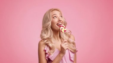 Lolipop Yiyen Kadın Öpüşen Şeker Göz Kırpan Göz, Pembe Arkaplan