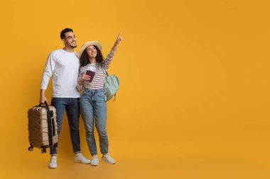 Tatil teklifi. Çantalı ve pasaportlu mutlu orta doğu çifti