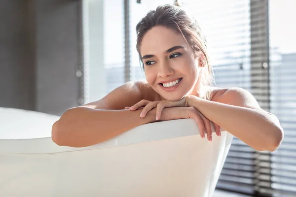 ホームスパ。浴槽で休んでいる若い女性の笑顔の肖像 — ストック写真