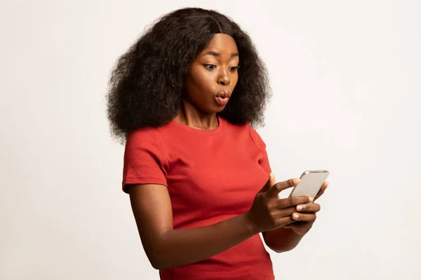 놀란 젊은 흑인 여성의 초상화 - 스마트폰 화면을 보고 있는 모습 — 스톡 사진