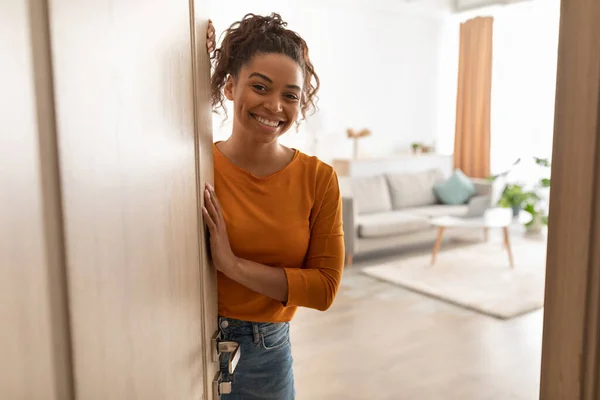 Glada afroamerikanska kvinnliga öppna dörr leende stående hemma — Stockfoto