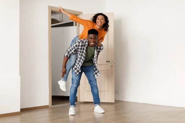 Uomo afroamericano che trasporta donna divertendosi ad entrare in una nuova casa — Foto Stock