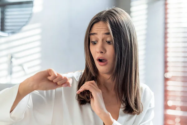 Donna scioccato guardando i suoi capelli secchi fragili mentre in piedi in bagno — Foto Stock