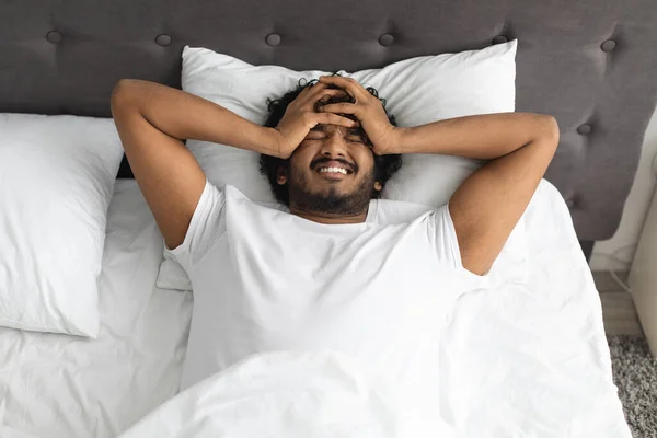 Irritált indiai srác szenved migrén, feküdt az ágyban — Stock Fotó