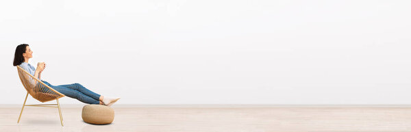 Relaxed millennial woman chilling at home, drinking coffee