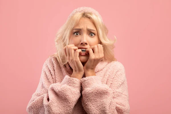 Rädd ung dam bita naglar med oro, har känslomässig stress, reagerar på skrämmande nyheter, rosa studio bakgrund — Stockfoto