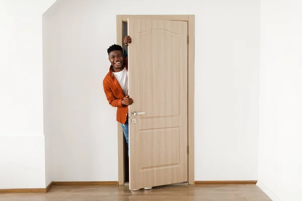 Gelukkige Afro-Amerikaanse man lacht bij het openen van de deur thuis — Stockfoto