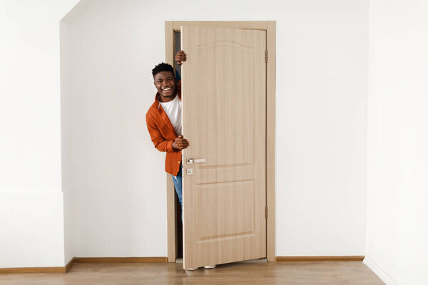 Happy African American Man Smiling Opening The Door At Home