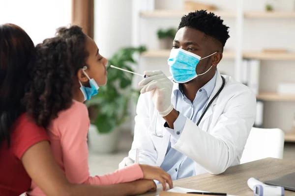 Médico afroamericano tomando hisopo nasal de un niño —  Fotos de Stock
