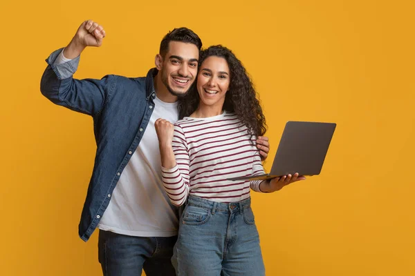 Νίκη στο διαδίκτυο. Πορτρέτο του ενθουσιασμένοι αραβικό ζευγάρι γιορτάζει την επιτυχία με το laptop — Φωτογραφία Αρχείου